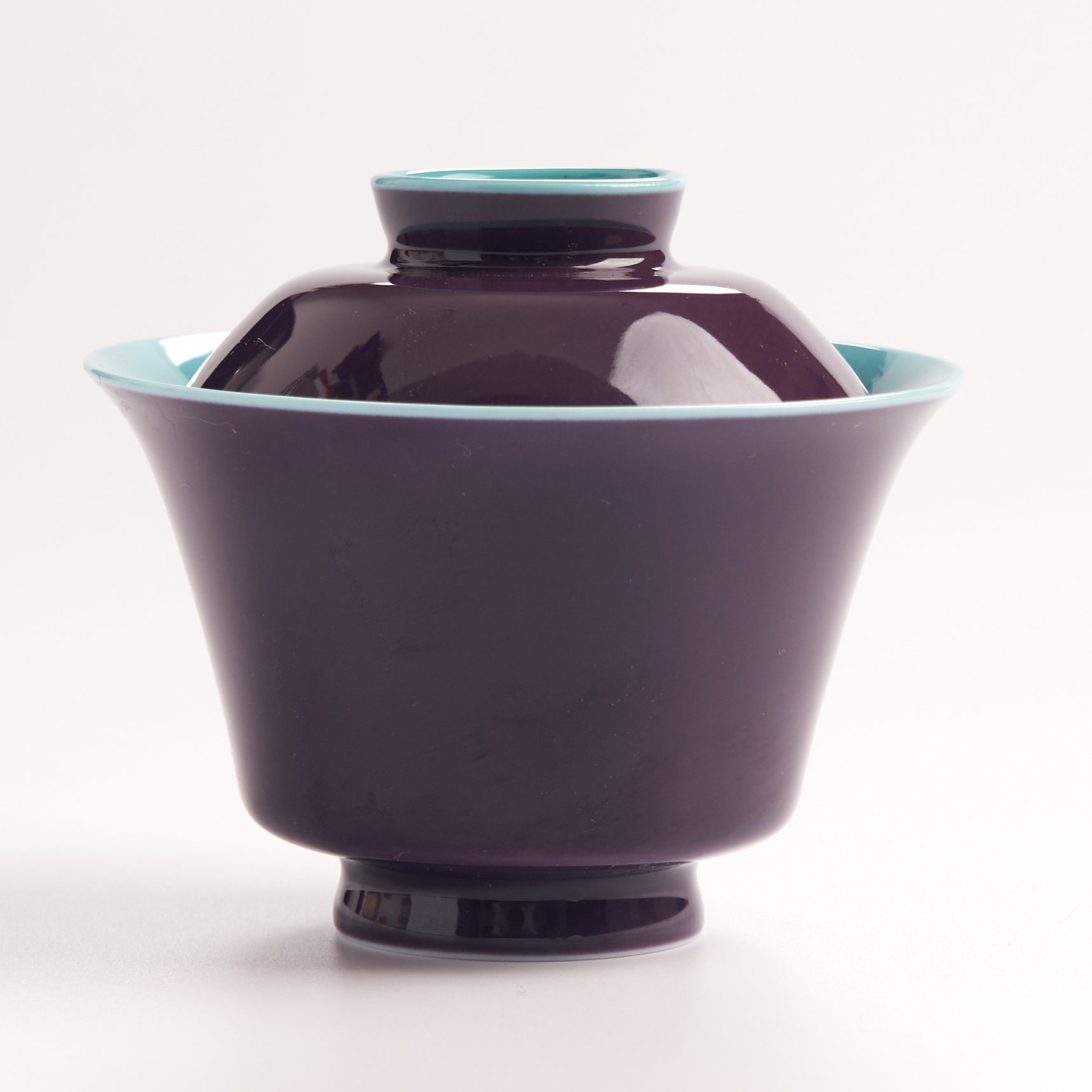 Purple ceramic bowl with a matching lid on a white background