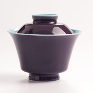 Purple ceramic bowl with a matching lid on a white background