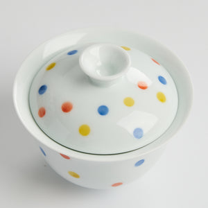 White ceramic container with colorful polka dot pattern on a white background