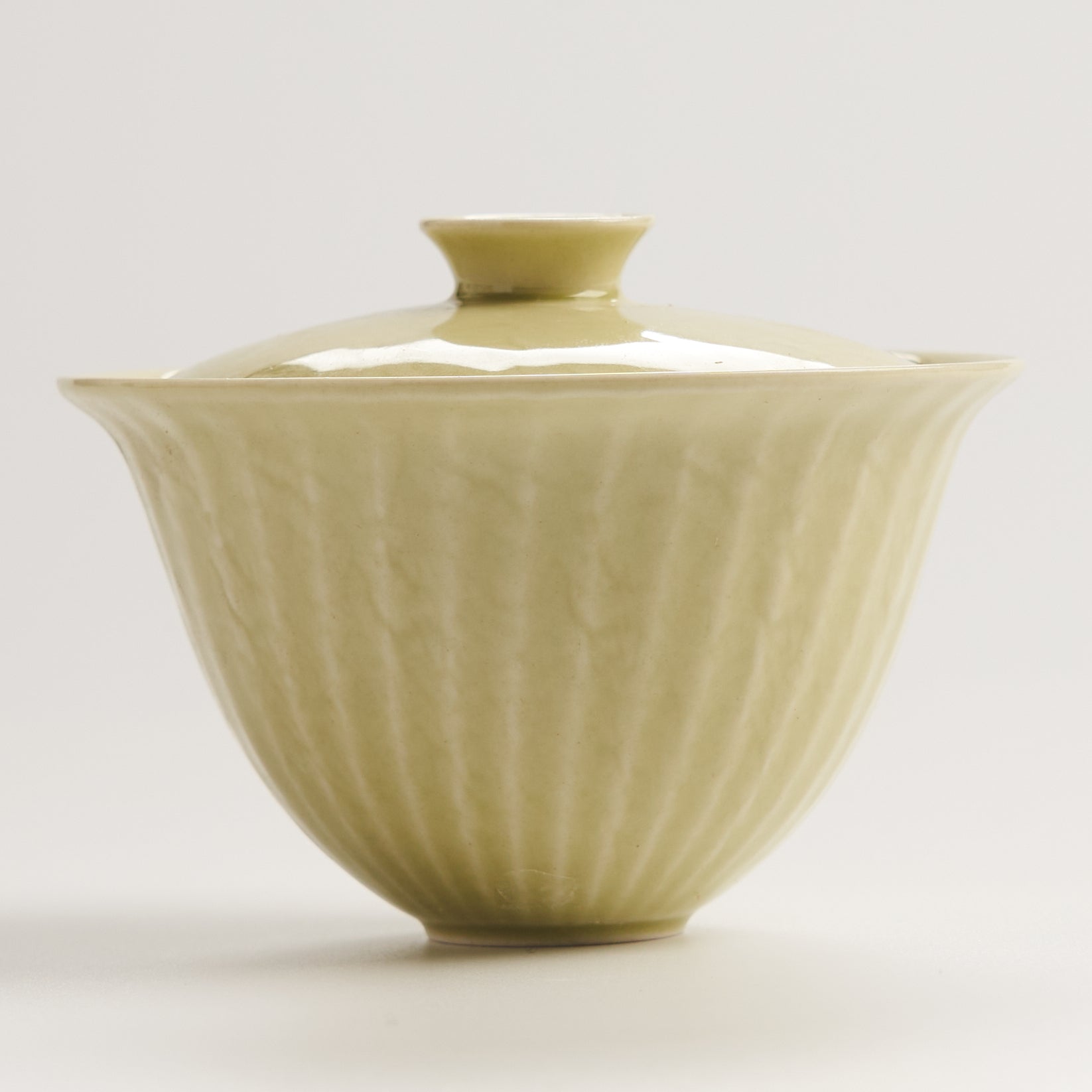 side view of yellow fluted ceramic gaiwan showing rounded shape and rim