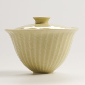 side view of yellow fluted ceramic gaiwan showing rounded shape and rim