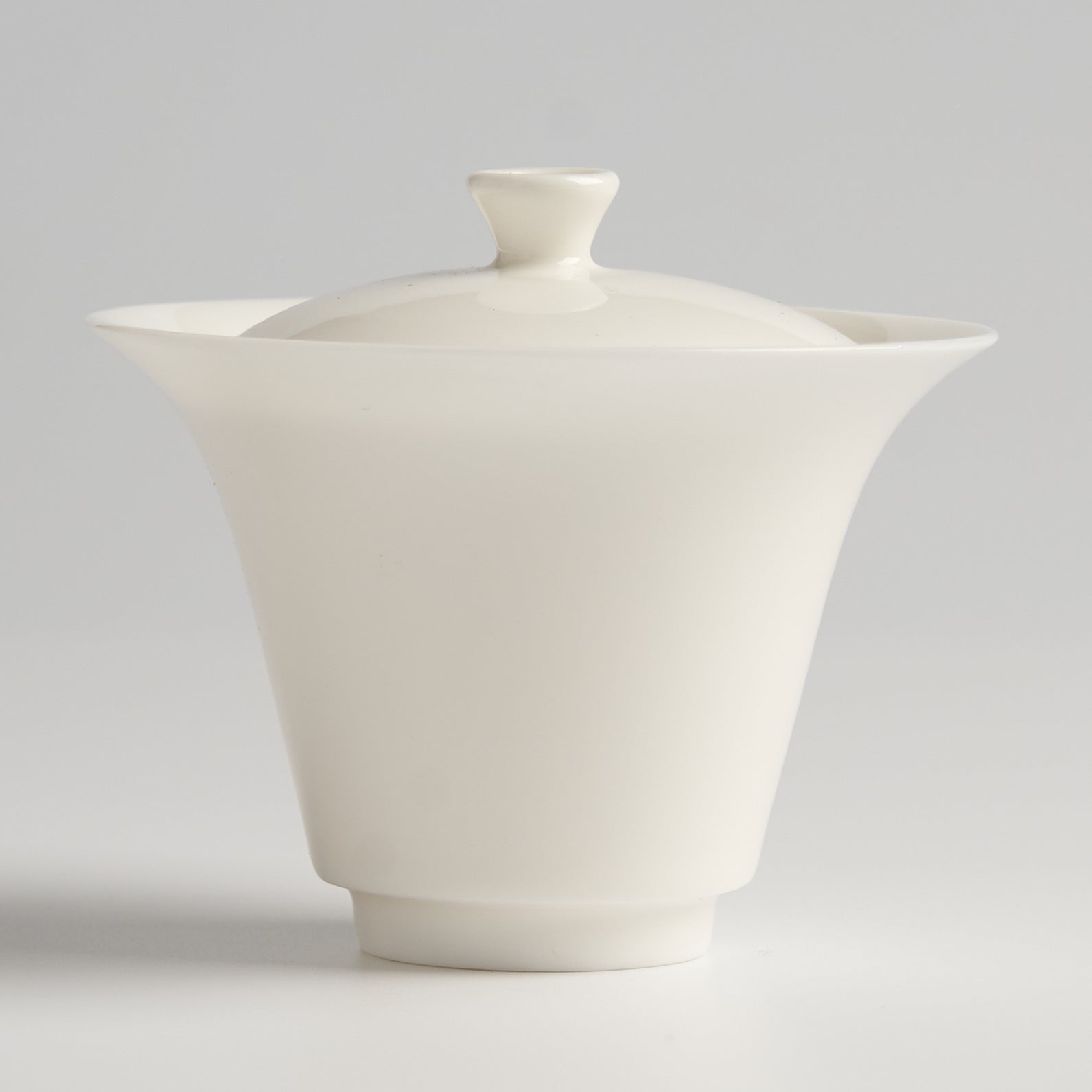 White ceramic teapot on a light gray background