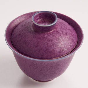 Purple ceramic bowl with a matching lid on a white background