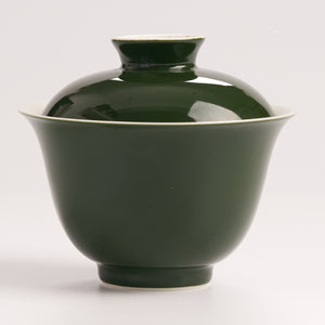 Side view of green ceramic gaiwan with lid on a white backgroundn