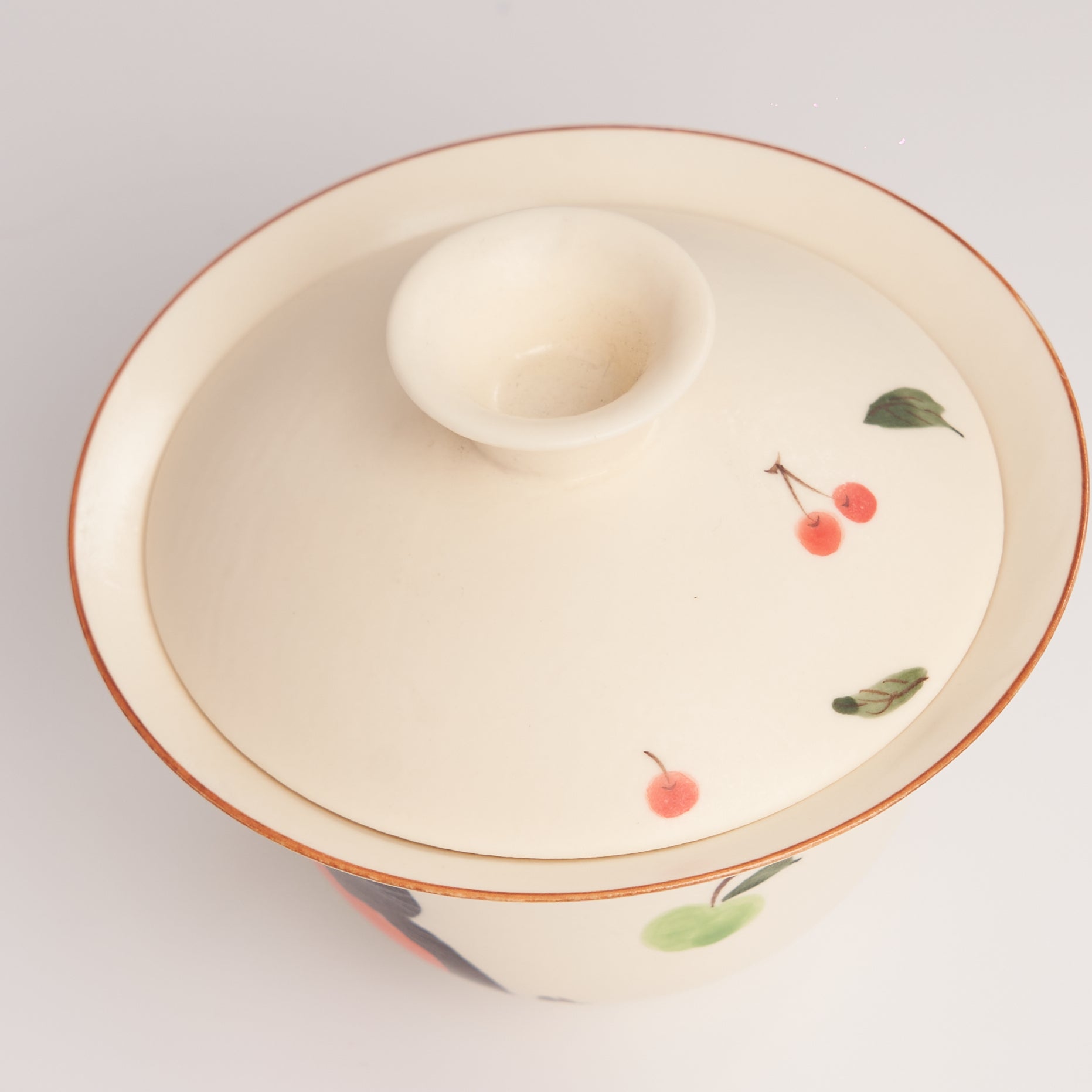 Ceramic gaiwan featuring cherry designs on a light gray background