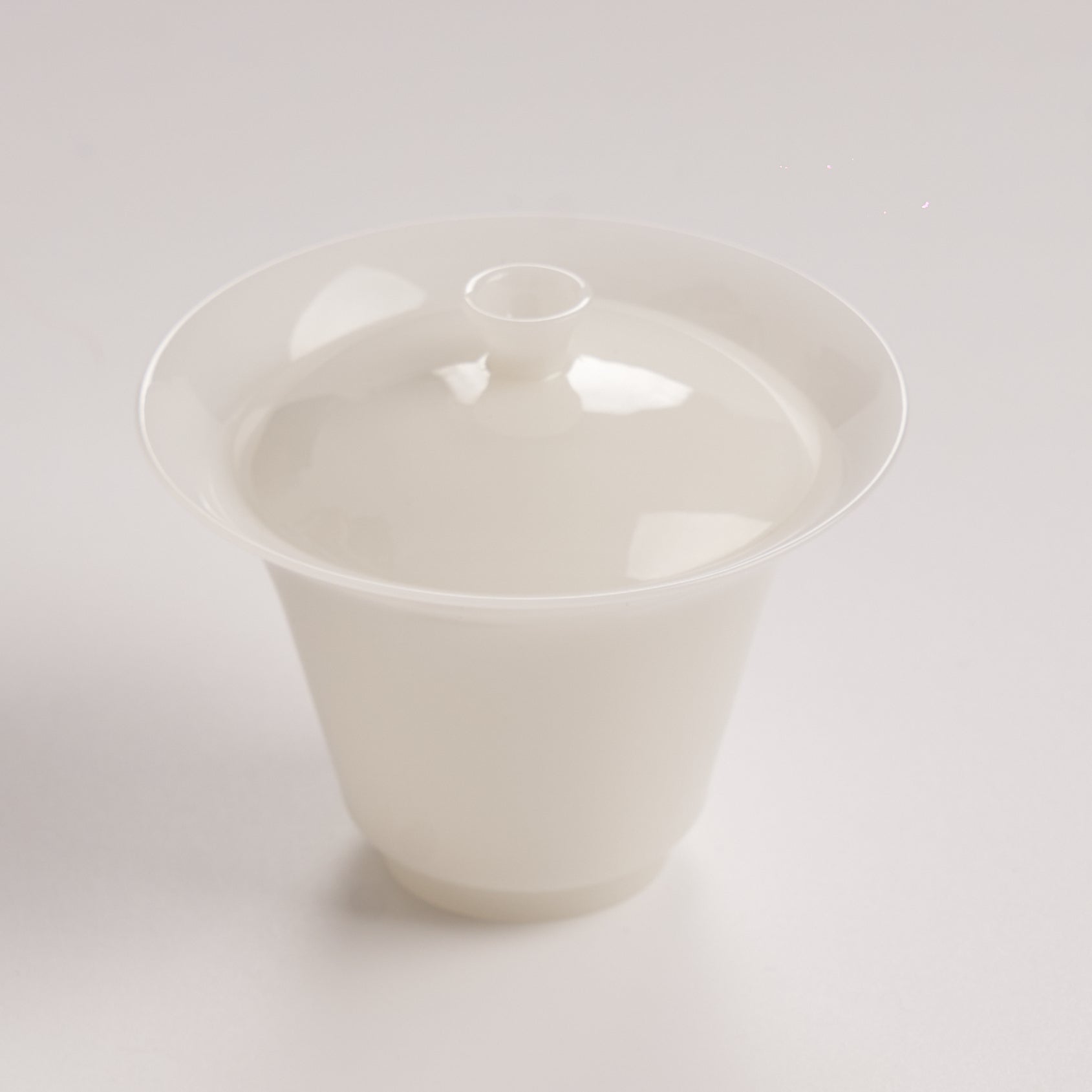 White ceramic jade like with lid on a light gray background