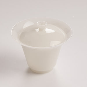 White ceramic jade like with lid on a light gray background