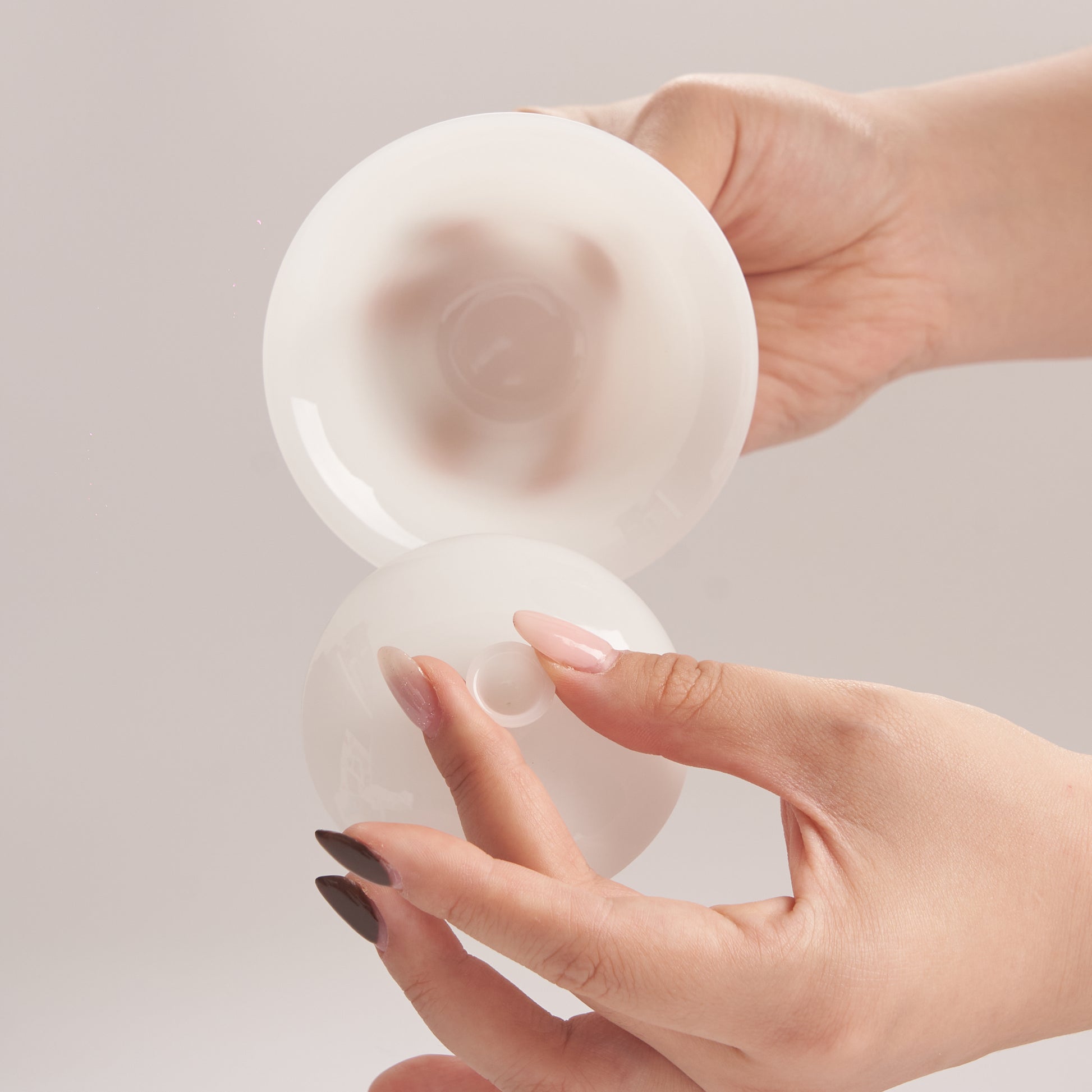 Hand holding a jade like gaiwan against a light background