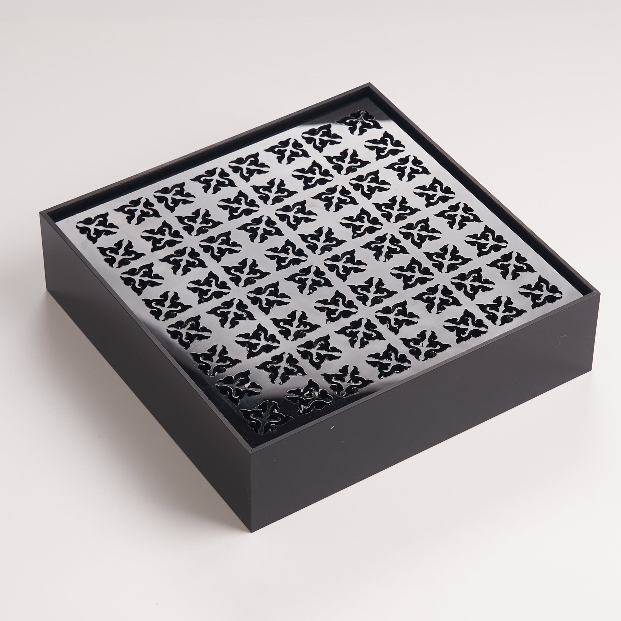 Modern black acrylic tea tray featuring precision cutout pattern