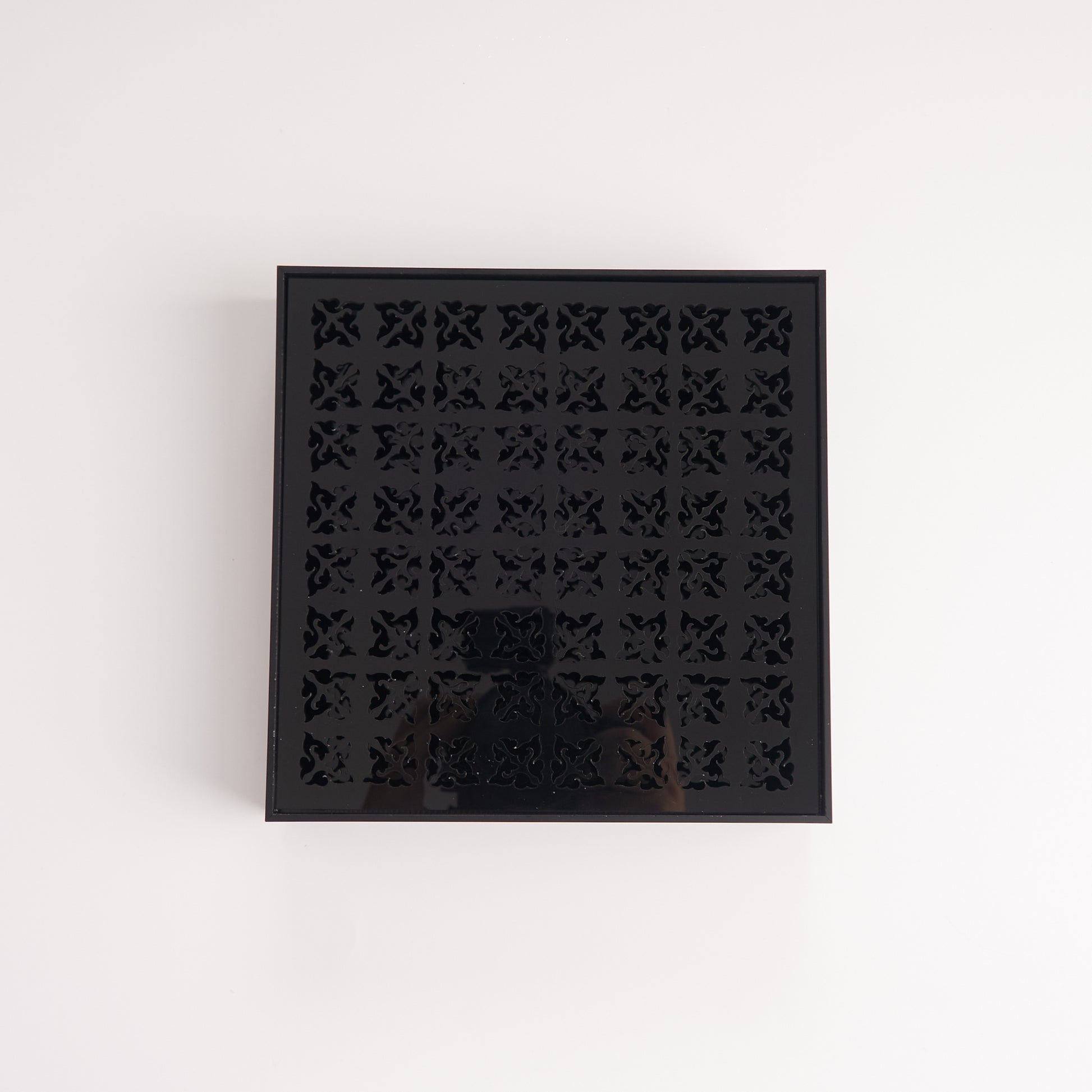Black acrylic tea tray with geometric cutout surface, top view