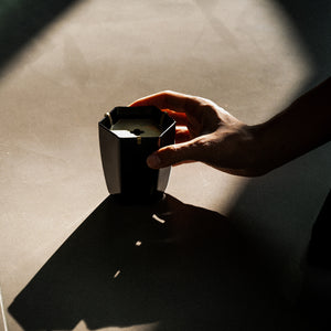 Hand holding black iron waste bowl