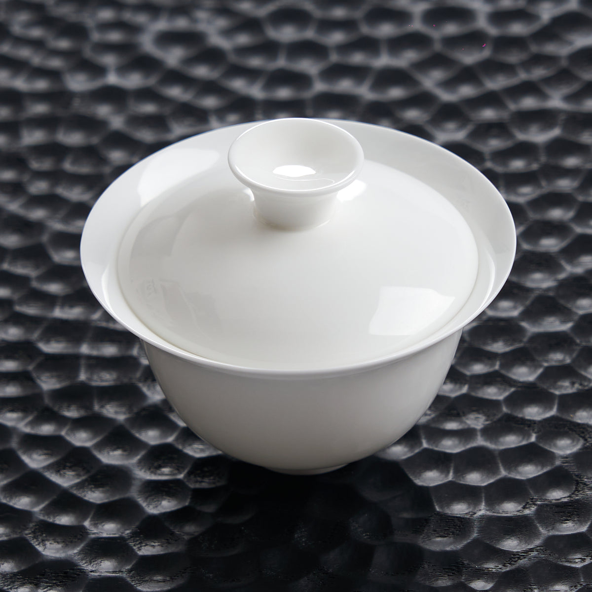 80 ml white bone china gaiwan photographed on a dark textured tea tray