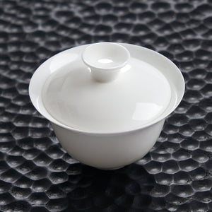 80 ml white bone china gaiwan photographed on a dark textured tea tray
