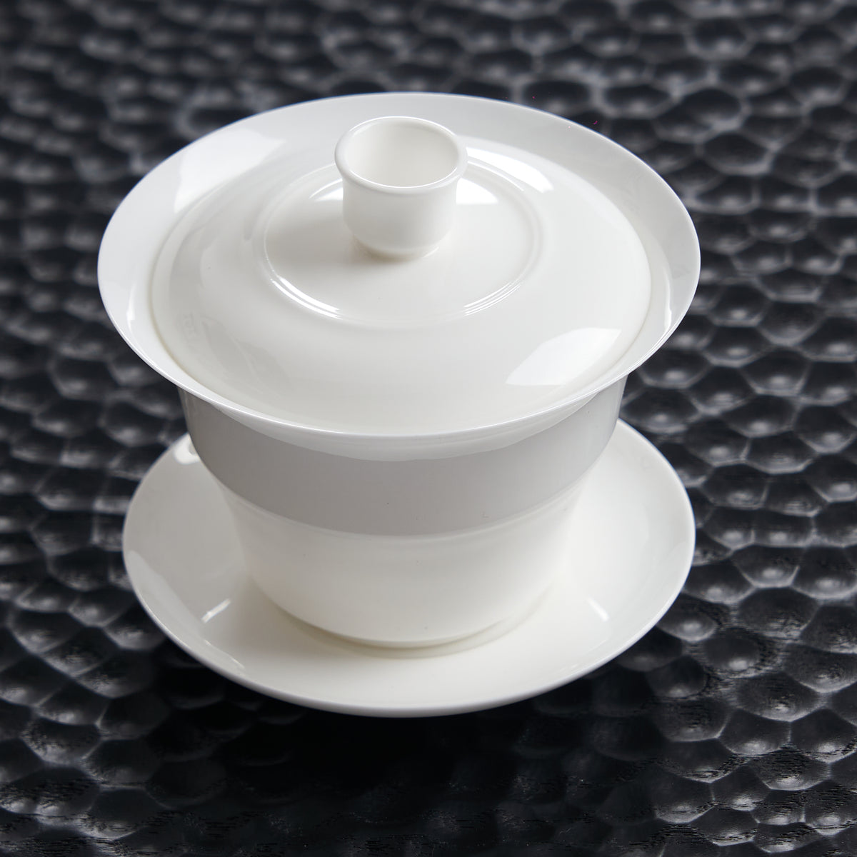 Bamboo-joint bone china gaiwan with saucer on a dark textured tea tray
