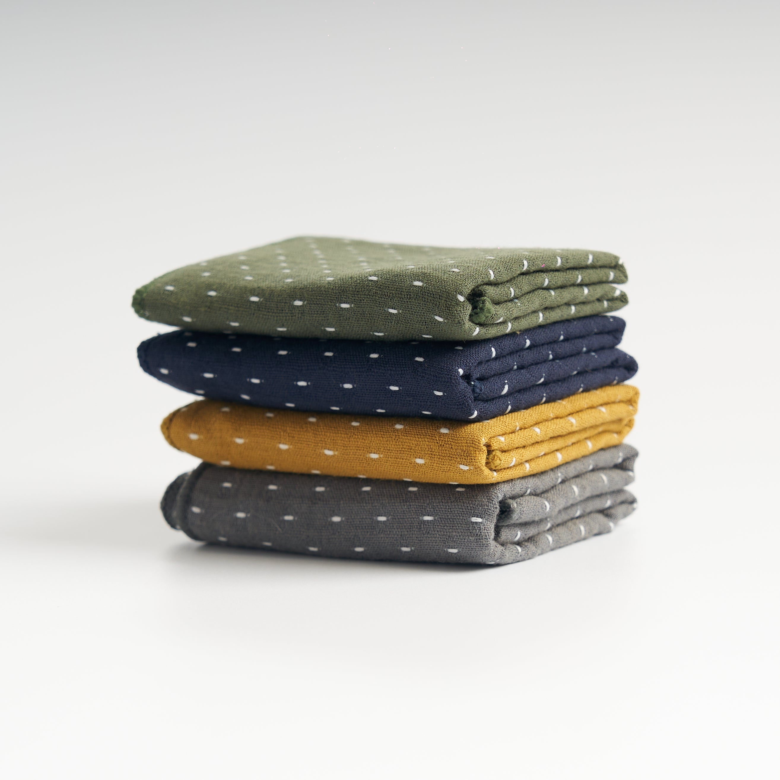Thick cotton-linen tea towels in gray, yellow, blue, and green, stacked front view