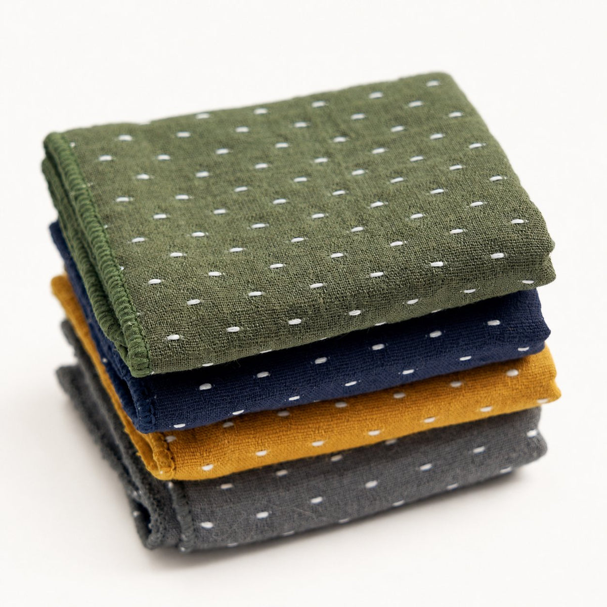 Thick cotton-linen tea towels in green, blue, yellow, and gray, slightly overhead view