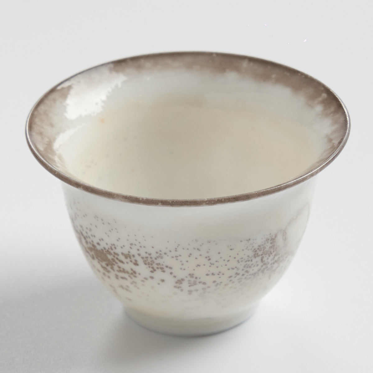 Rustic speckled stoneware teacup set, close three-quarter view
