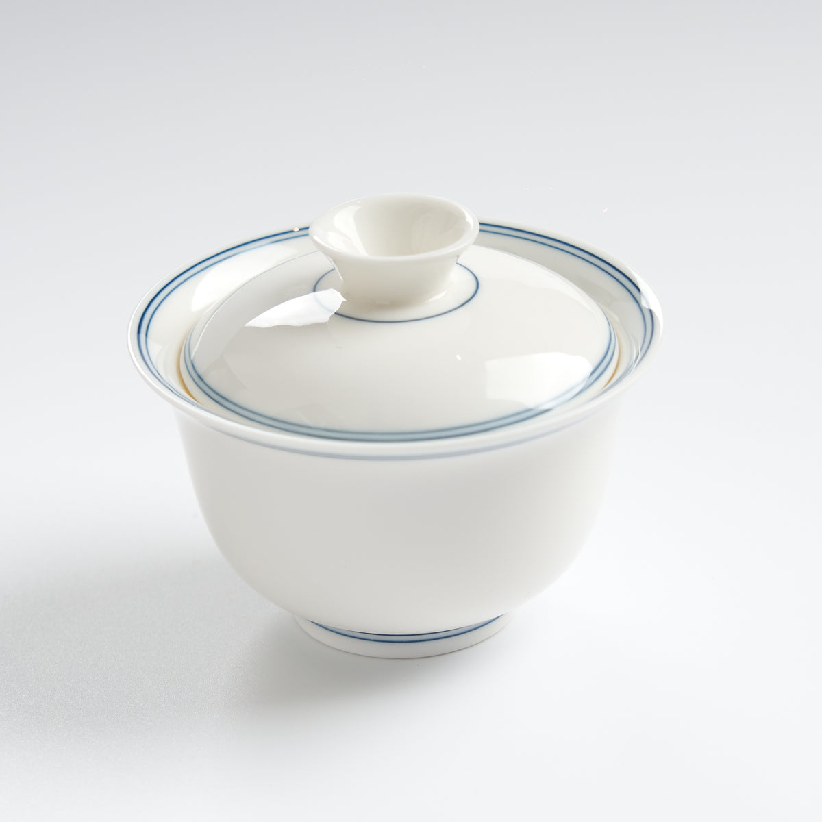 Sheep-fat white porcelain blue-rim evaluation gaiwan, three-quarter overhead view
