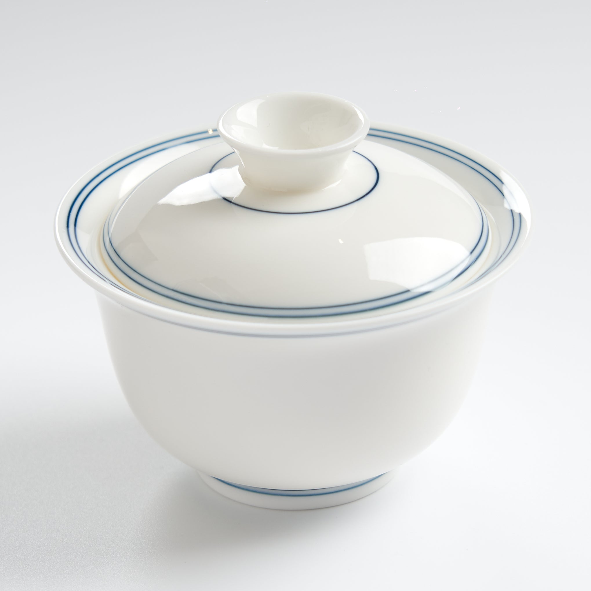 Sheep-fat white porcelain blue-rim evaluation gaiwan, closer three-quarter overhead view