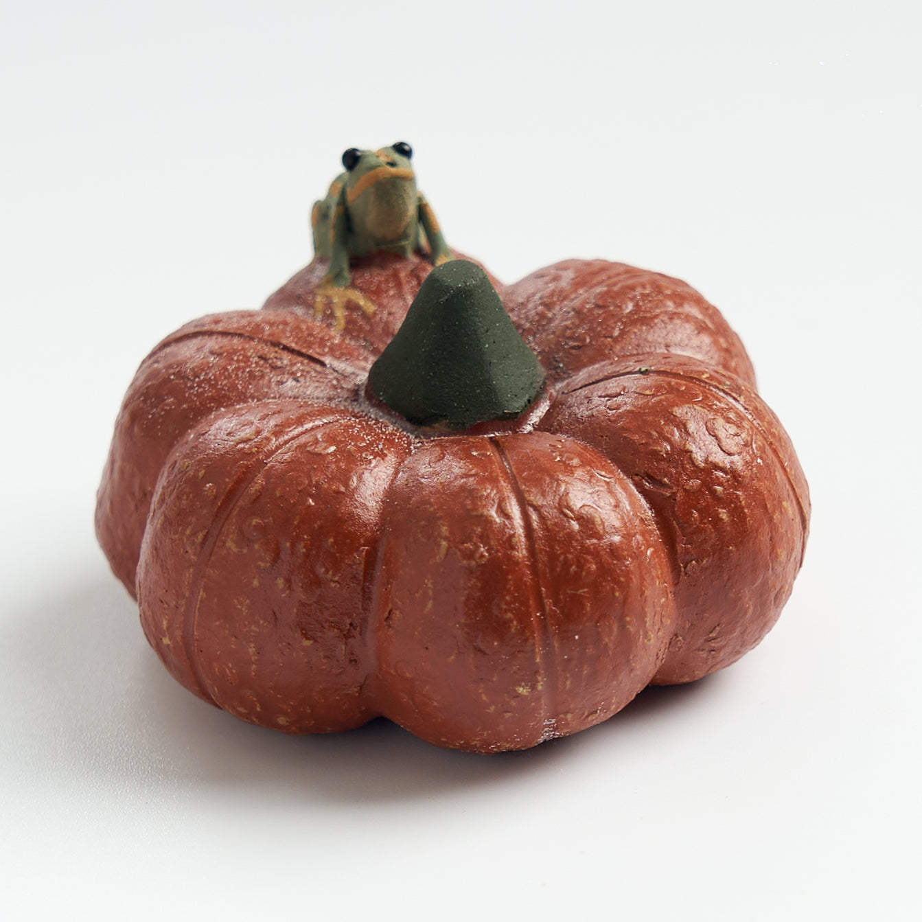 Handmade frog tea pet on a short pumpkin, three-quarter view