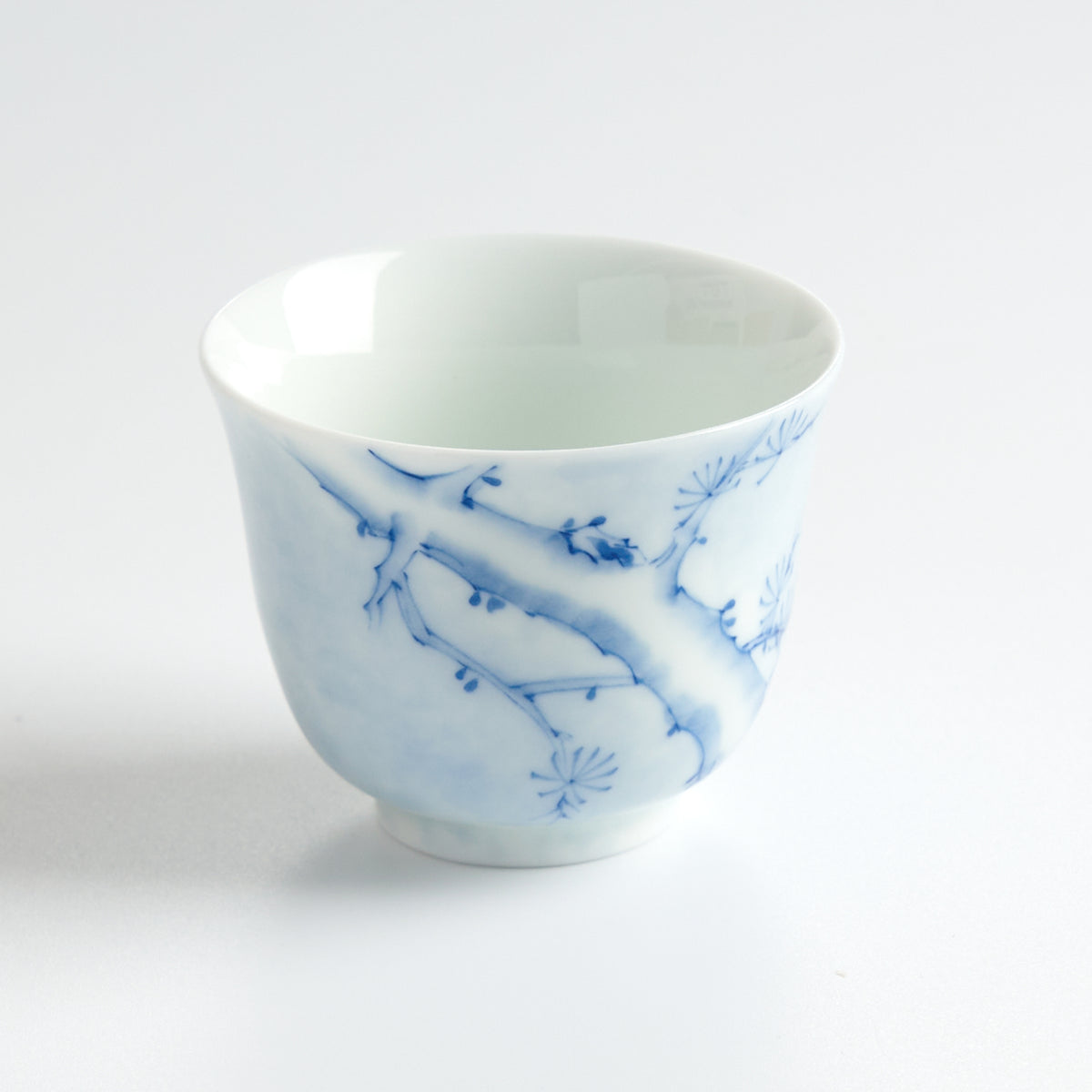 Underglaze Blue-and-White Hand-Painted Pine Cup — angled view