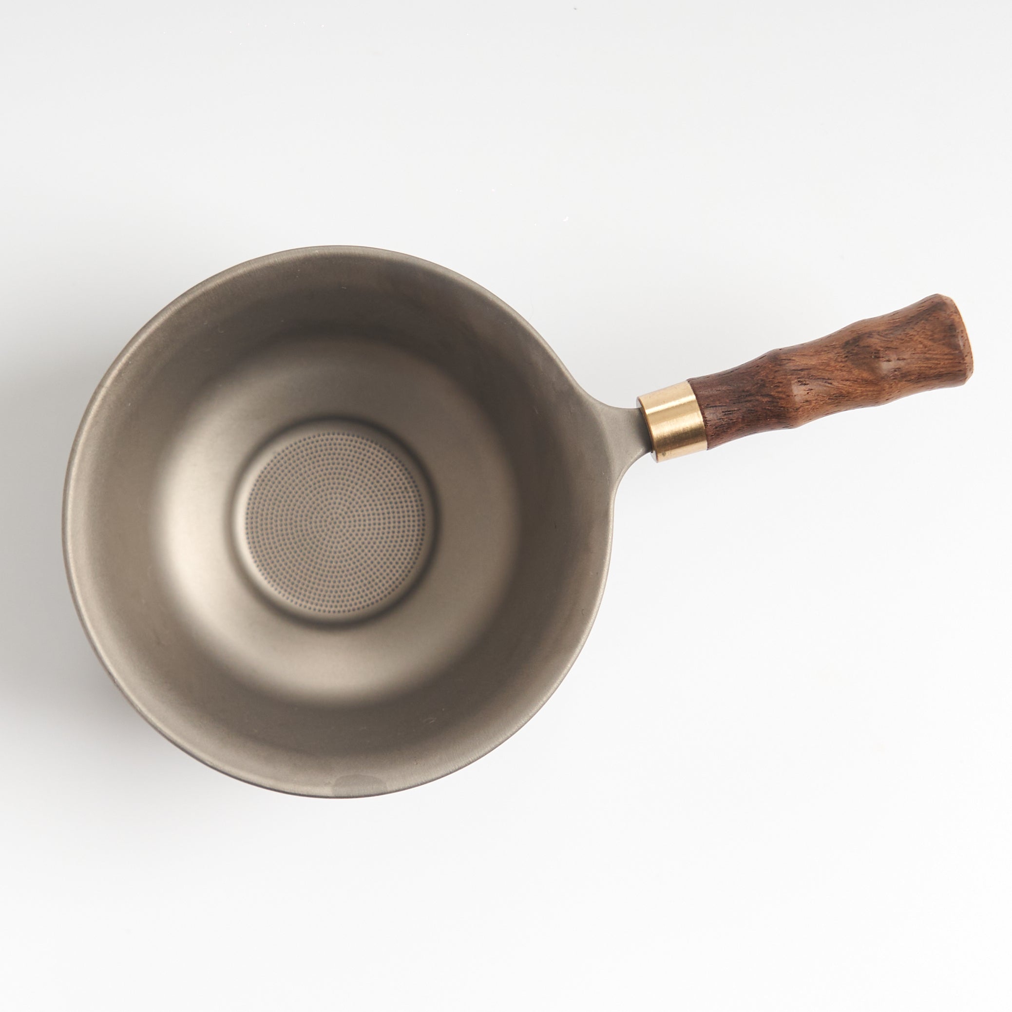 Stainless-steel tea strainer with wooden base, top-down mesh detail