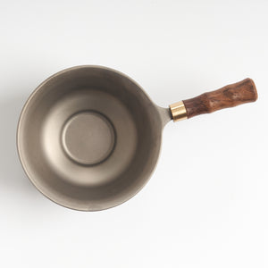 Stainless-steel tea strainer with wooden base, top-down mesh detail